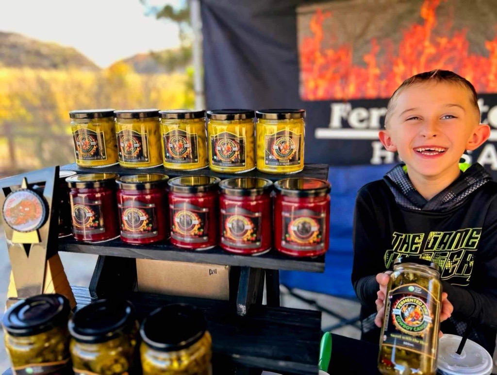 A boy poses with some hot sauces